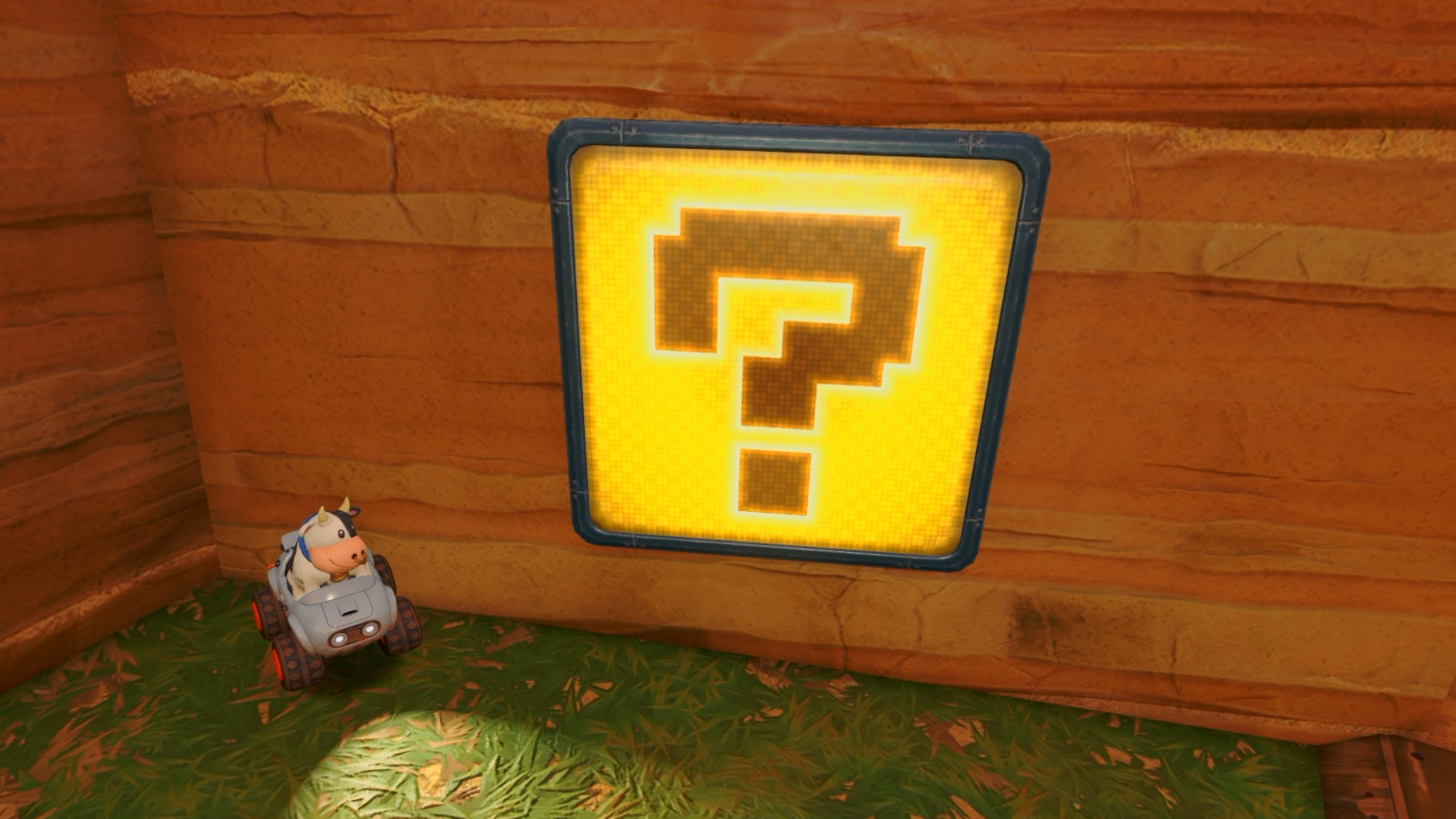 Cow in a gray car sitting beside a "?" panel on a wall in Mario Kart World.